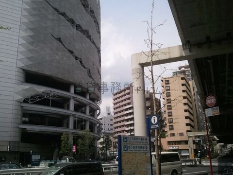 高速道路下の交差点にあるデザイン的なオフィスビルです