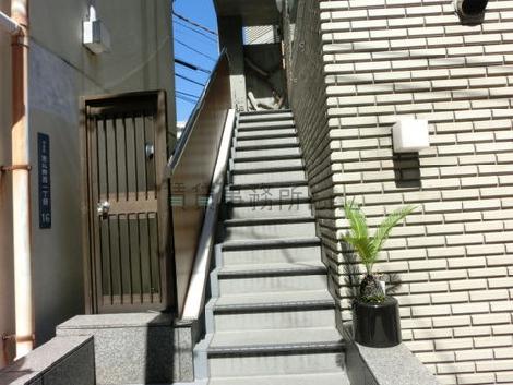 正面左には2階店舗への階段