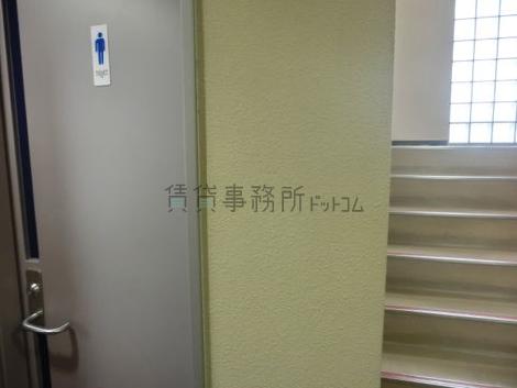 エントランス奥、階段脇に男子トイレが設置されています