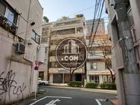 ５階以上の壁面に傾斜がある、７階建ての建物です